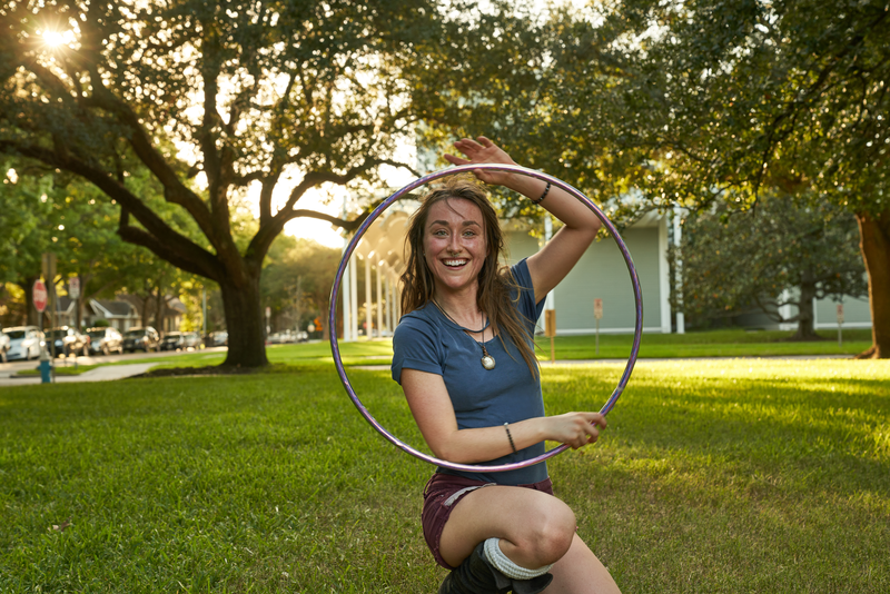Woman looking at camera, smiling, holding hula hoop